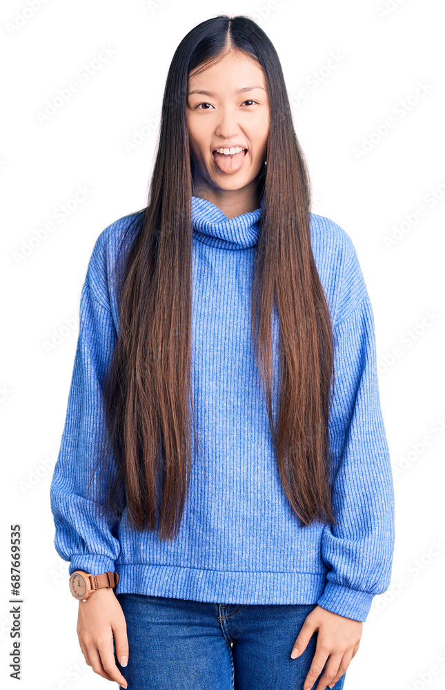 Young beautiful chinese woman wearing casual turtleneck sweater sticking tongue out happy with funny expression. emotion concept. Young beautiful chinese woman wearing casual turtleneck sweater sticking tongue out happy with funny expression. emotion concept.
