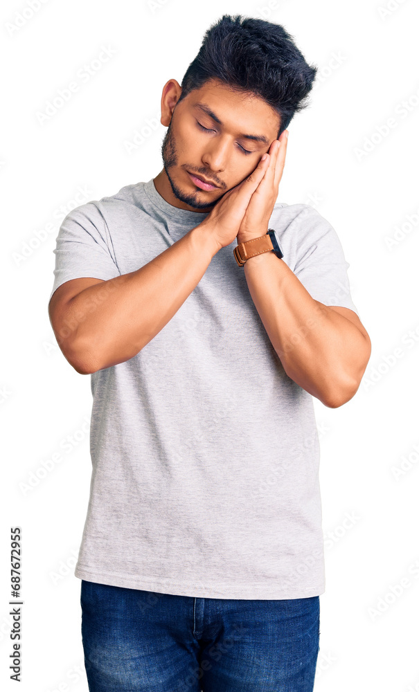 Handsome latin american young man wearing casual tshirt sleeping tired dreaming and posing with hands together while smiling with closed eyes. Handsome latin american young man wearing casual tshirt sleeping tired dreaming and posing with hands together while smiling with closed eyes.