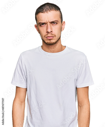 Hispanic young man wearing casual white t shirt skeptic and nervous, frowning upset because of problem. negative person.