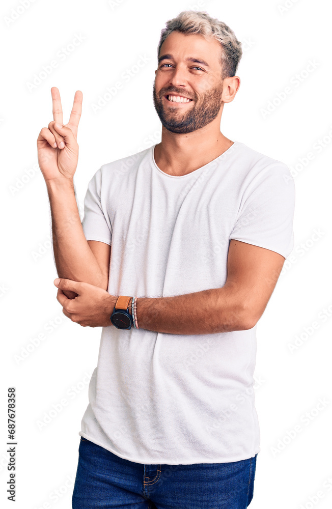 Young handsome blond man wearing casual t-shirt with a big smile on face, pointing with hand and finger to the side looking at the camera. Young handsome blond man wearing casual t-shirt with a big smile on face, pointing with hand and finger to the side looking at the camera.
