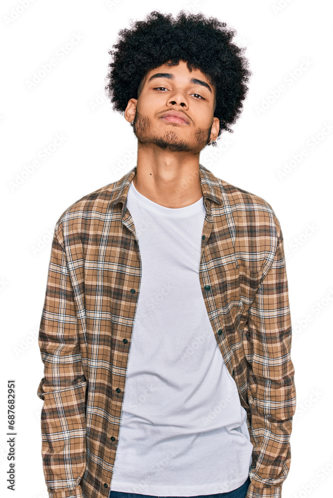 Young african american man with afro hair wearing casual clothes relaxed with serious expression on face. simple and natural looking at the camera. Young african american man with afro hair wearing casual clothes relaxed with serious expression on face. simple and natural looking at the camera.