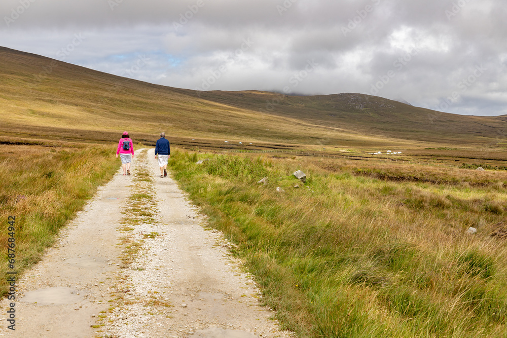 Couple walking around bogs with mountains in background