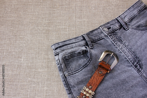 Brown leather belt and gray burlap jeans photo