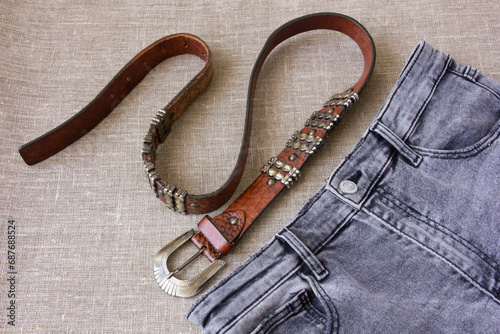 Brown leather belt and gray burlap jeans