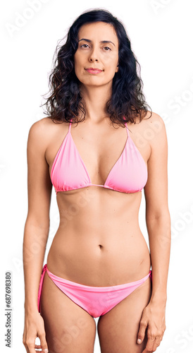 Young beautiful hispanic woman wearing bikini relaxed with serious expression on face. simple and natural looking at the camera.