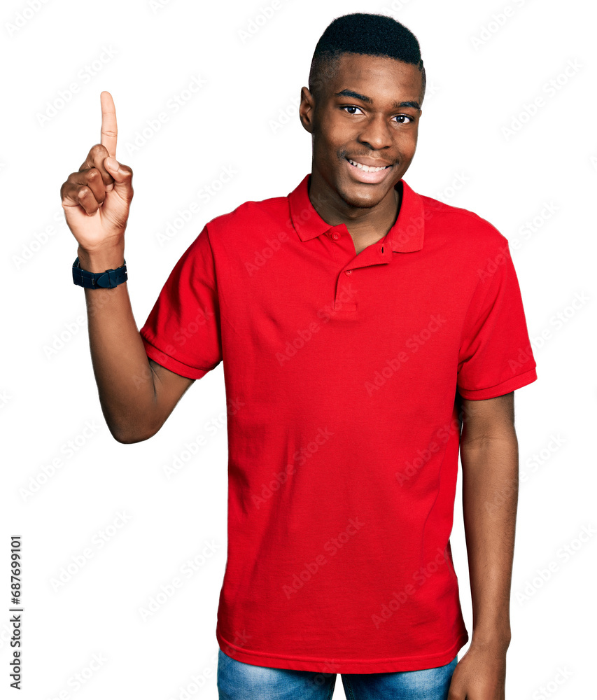 Young african american man wearing casual red t shirt pointing finger up with successful idea. exited and happy. number one. Young african american man wearing casual red t shirt pointing finger up with successful idea. exited and happy. number one.