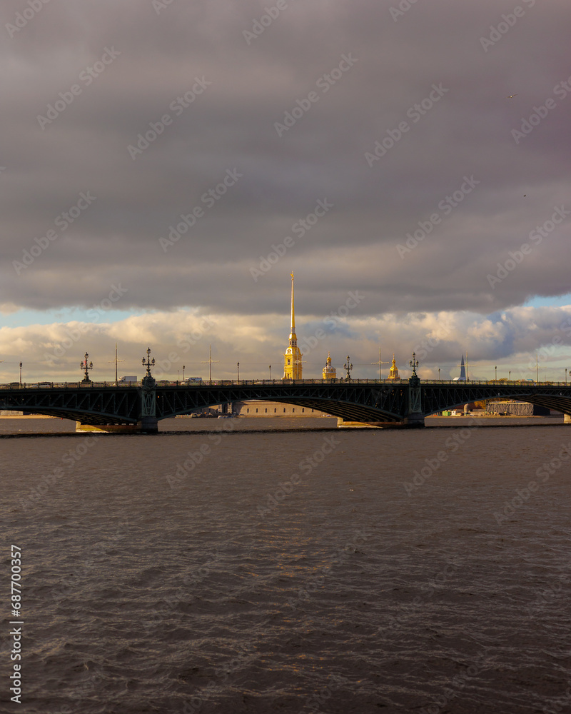 large bridge over river in central business part of city, sights and dramatic sky. beautiful city landscape, sea view and bridge in evening light