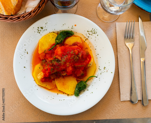 Delicious fried cod served on plate with vegetables samfaina.. photo