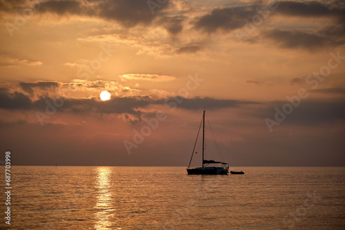 Un velero descansa durante la salida del sol en la costa de Peñíscola.