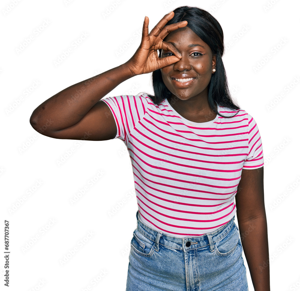 African young woman wearing casual striped t shirt doing ok gesture with hand smiling, eye looking through fingers with happy face. African young woman wearing casual striped t shirt doing ok gesture with hand smiling, eye looking through fingers with happy face.
