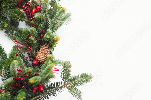 Christmas background with Christmas tree branches, cones and red berries, winter festive composition with copy space