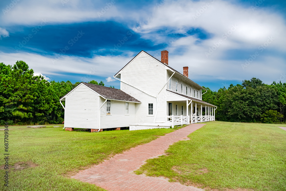 Old house historic district area of Hatteras Island North Carolina. Beautiful white building has two porches.