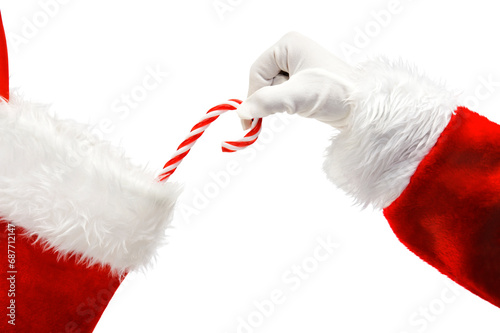 Santa Claus placing a traditional candy cane into a Christmas Stocking isolated
