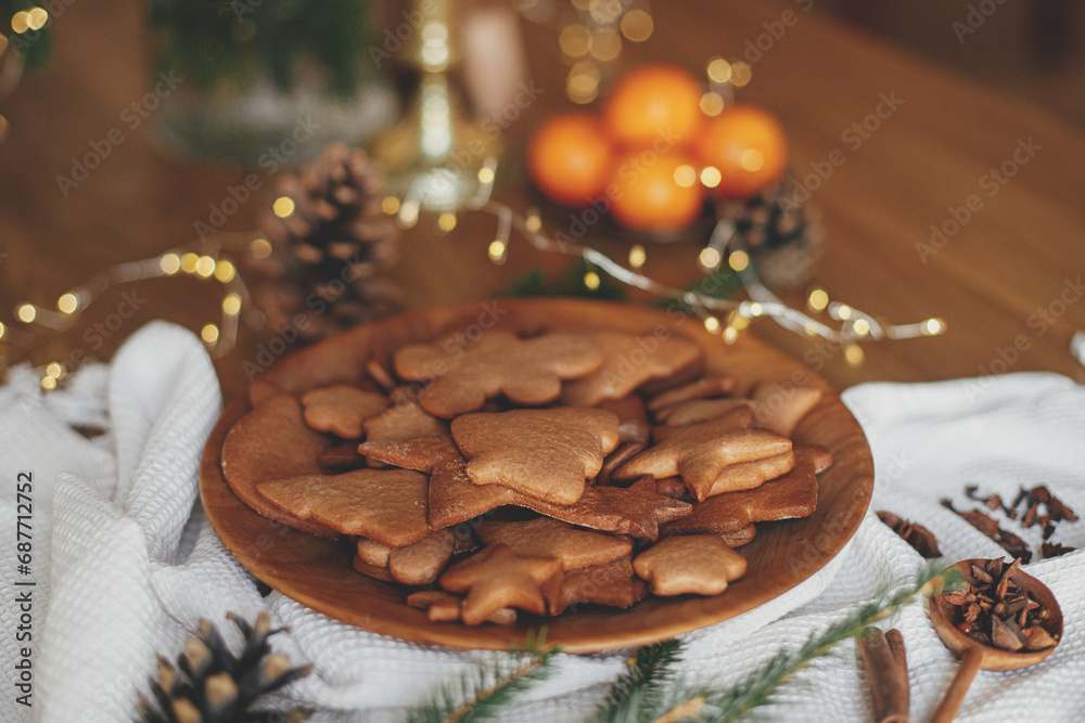 Christmas gingerbread cookies in wooden plate on rustic table with fir branches, pinecone, napkin. Merry Christmas! Delicious fresh gingerbread cookies close up, atmospheric holiday Christmas gingerbread cookies in wooden plate on rustic table with fir branches, pinecone, napkin. Merry Christmas! Delicious fresh gingerbread cookies close up, atmospheric holiday