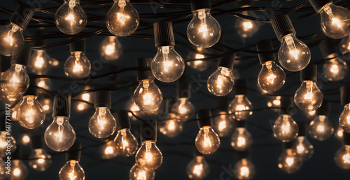 Luminous incandescent lamps hang in the form of a garland on wires. Garland background. Incandescent lamps.