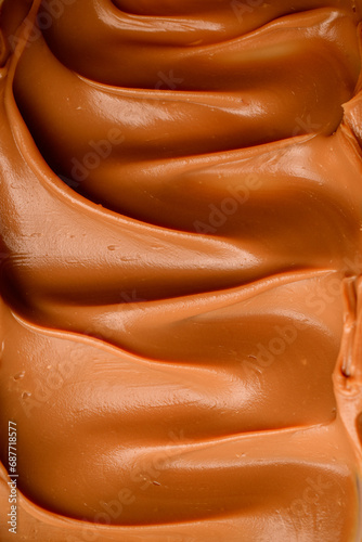 Photo from above, close-up of brown cream, distributed evenly with a wavy surface