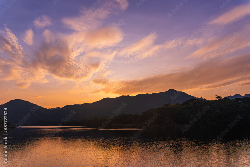 Beautiful lakeside view from a small lake in Kanchanaburi Thailand, with water reflect sunset sky