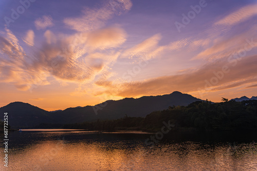 Beautiful lakeside view from a small lake in Kanchanaburi Thailand, with water reflect sunset sky