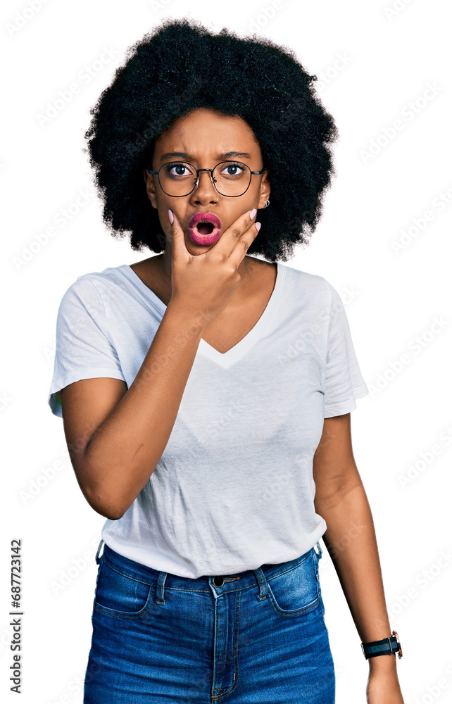 Young african american woman wearing casual white t shirt looking fascinated with disbelief, surprise and amazed expression with hands on chin Young african american woman wearing casual white t shirt looking fascinated with disbelief, surprise and amazed expression with hands on chin