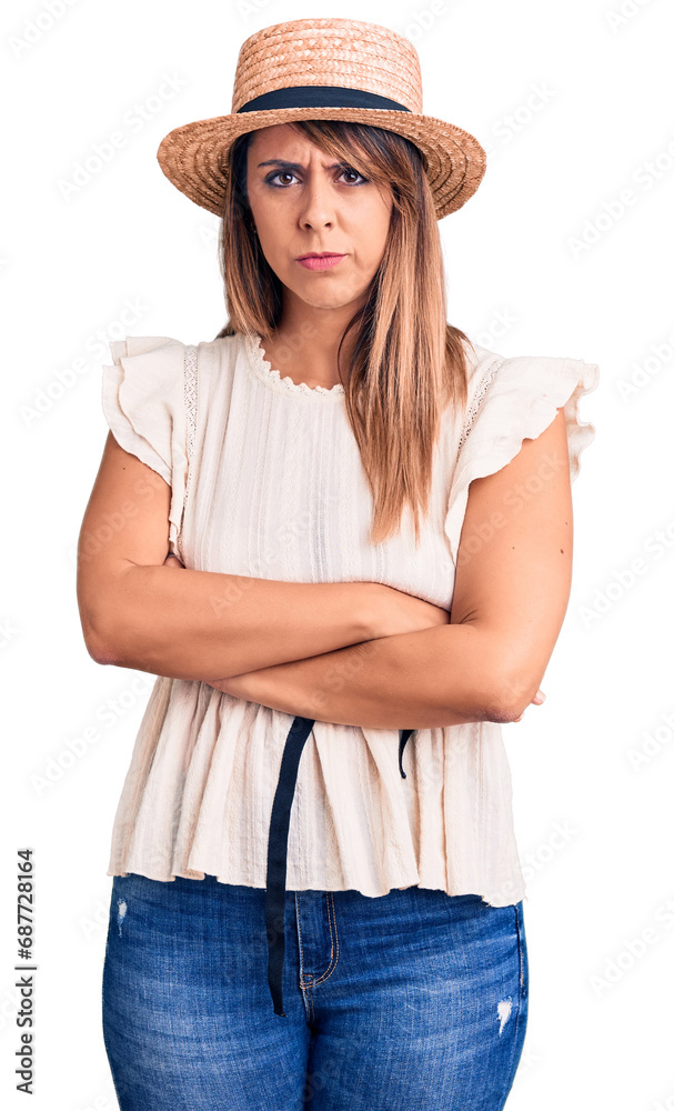 Young beautiful woman wearing summer hat and t-shirt skeptic and nervous, disapproving expression on face with crossed arms. negative person. Young beautiful woman wearing summer hat and t-shirt skeptic and nervous, disapproving expression on face with crossed arms. negative person.