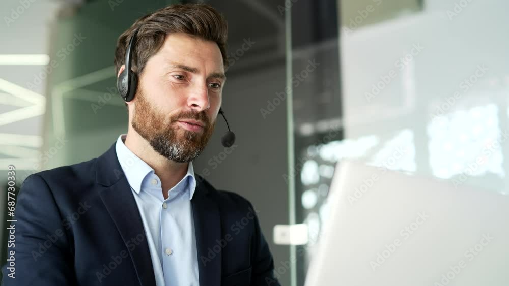 A corporate operator who works in customer support speaks on a video call using a laptop. Call center agent in wireless headset helping clients with complaints in office. Online consultation. Close up