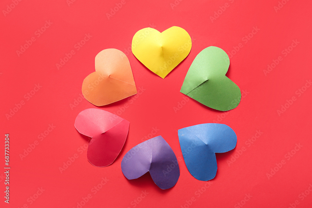 Frame made of colorful paper hearts on red background. LGBT concept Frame made of colorful paper hearts on red background. LGBT concept