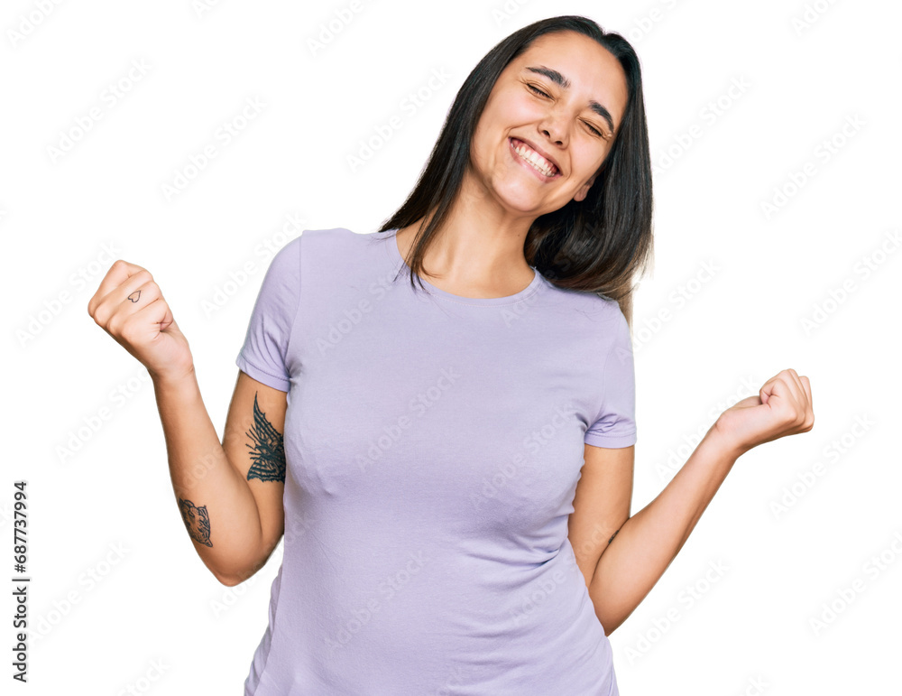 Young hispanic woman wearing casual clothes very happy and excited doing winner gesture with arms raised, smiling and screaming for success. celebration concept. Young hispanic woman wearing casual clothes very happy and excited doing winner gesture with arms raised, smiling and screaming for success. celebration concept.