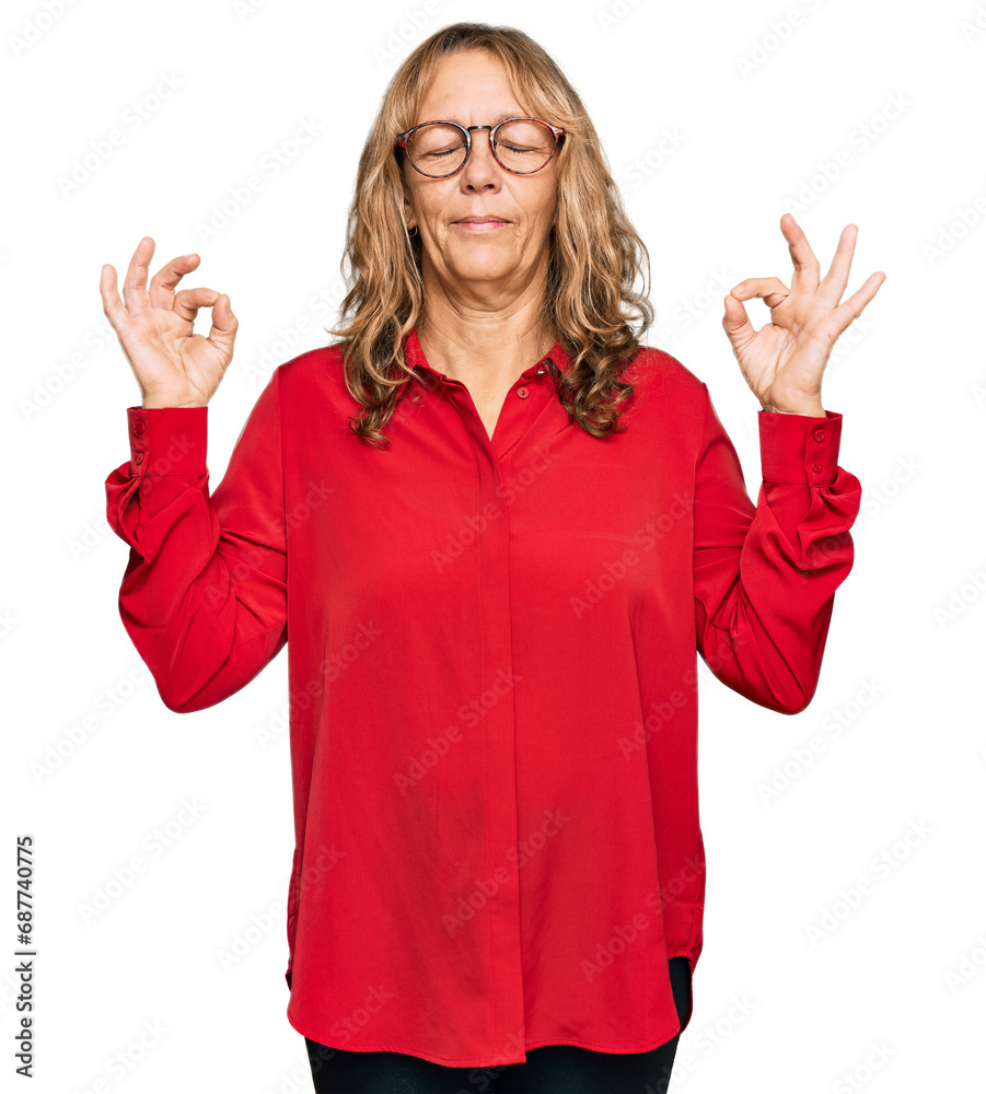 Middle age blonde woman wearing casual shirt over red background relax and smiling with eyes closed doing meditation gesture with fingers. yoga concept. Middle age blonde woman wearing casual shirt over red background relax and smiling with eyes closed doing meditation gesture with fingers. yoga concept.