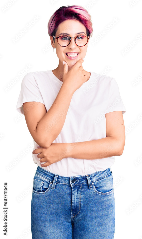Young beautiful woman with pink hair wearing casual clothes and glasses looking confident at the camera smiling with crossed arms and hand raised on chin. thinking positive. Young beautiful woman with pink hair wearing casual clothes and glasses looking confident at the camera smiling with crossed arms and hand raised on chin. thinking positive.