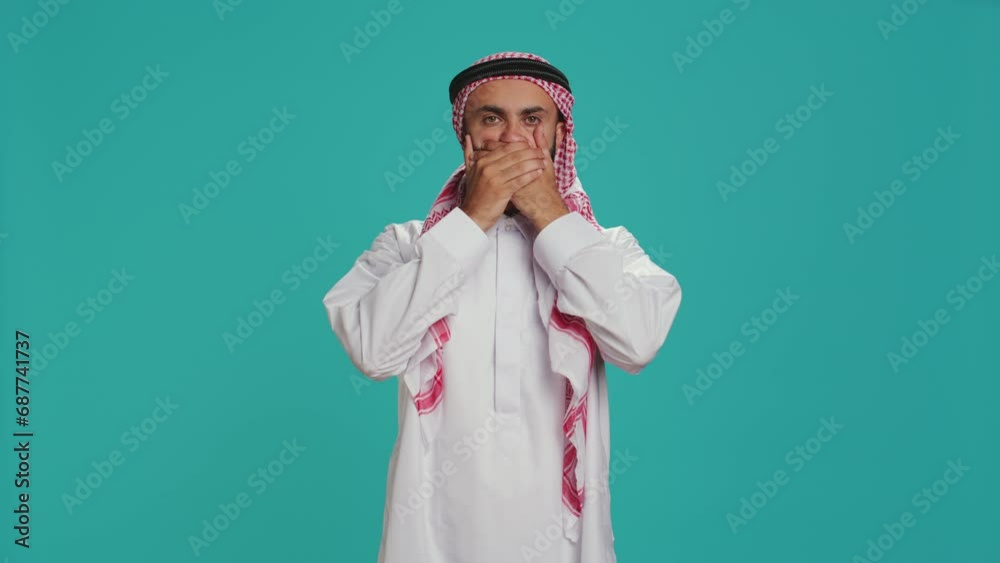 Muslim adult covers eyes, ears and mouth in studio, showcasing three wise monkeys metaphor sign. Middle eastern guy presenting dont hear, see or speak concept symbol in arabic clothes. Muslim adult covers eyes, ears and mouth in studio, showcasing three wise monkeys metaphor sign. Middle eastern guy presenting dont hear, see or speak concept symbol in arabic clothes.