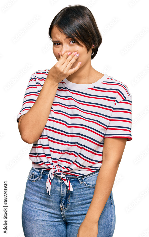 Beautiful young woman with short hair wearing casual clothes smelling something stinky and disgusting, intolerable smell, holding breath with fingers on nose. bad smell Beautiful young woman with short hair wearing casual clothes smelling something stinky and disgusting, intolerable smell, holding breath with fingers on nose. bad smell