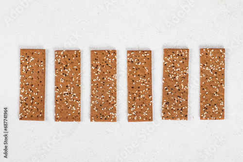 Vegan Buckwheat bread with sesame seeds and quinoa, in the form of thin strips. White background. Top view