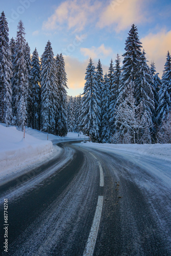 alpine road in the mountains with snow covered trees in winter