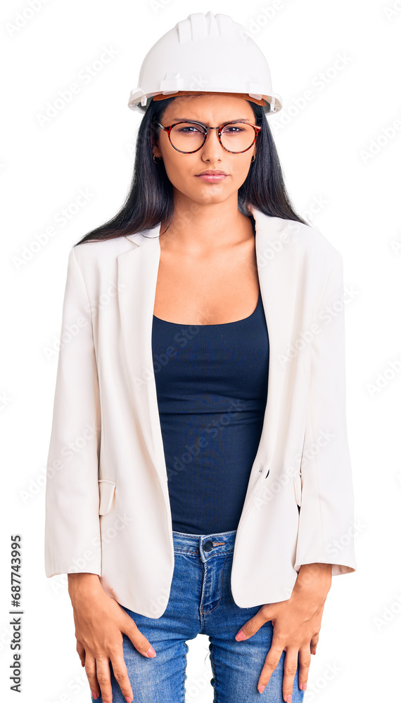 Young beautiful latin girl wearing architect hardhat and glasses skeptic and nervous, frowning upset because of problem. negative person. Young beautiful latin girl wearing architect hardhat and glasses skeptic and nervous, frowning upset because of problem. negative person.
