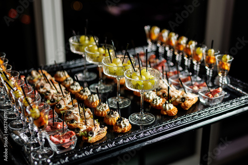 A black tray with a silver rim holding a selection of appetizers and finger foods photo