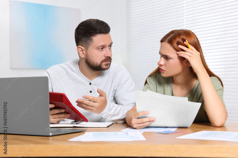 Fototapeta premium Couple calculating taxes at table in room