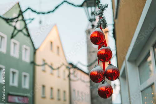 Christmas Red balls in the snow on the streets of a European city.Soft focus.Christmas street decor . Winter holidays in Europe