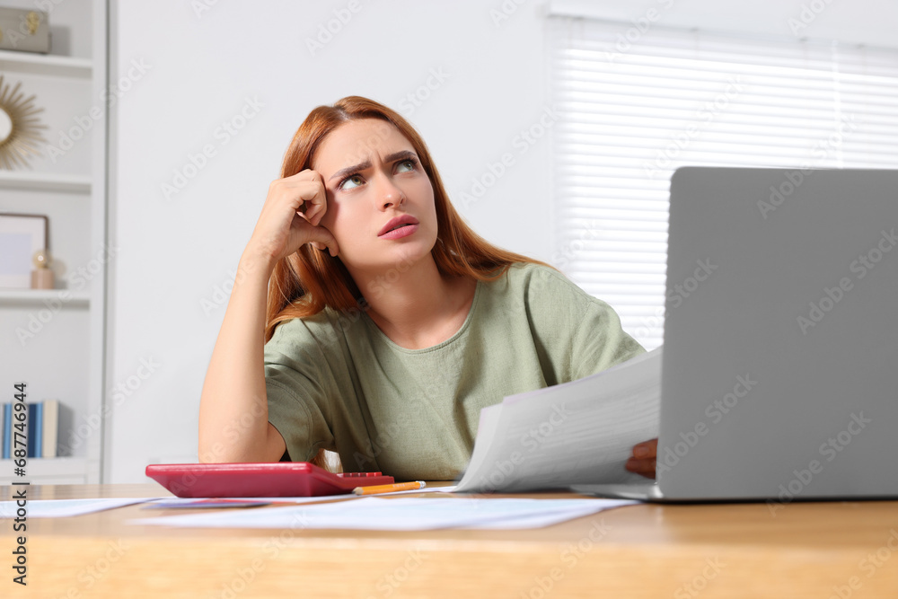 Woman doing taxes at table in room Woman doing taxes at table in room