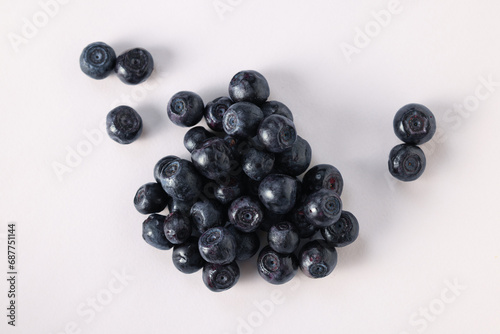 Pile of ripe bilberries on white background, flat lay