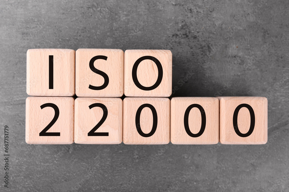 Wooden cubes with abbreviation ISO and number 22000 on grey textured table, flat lay Wooden cubes with abbreviation ISO and number 22000 on grey textured table, flat lay