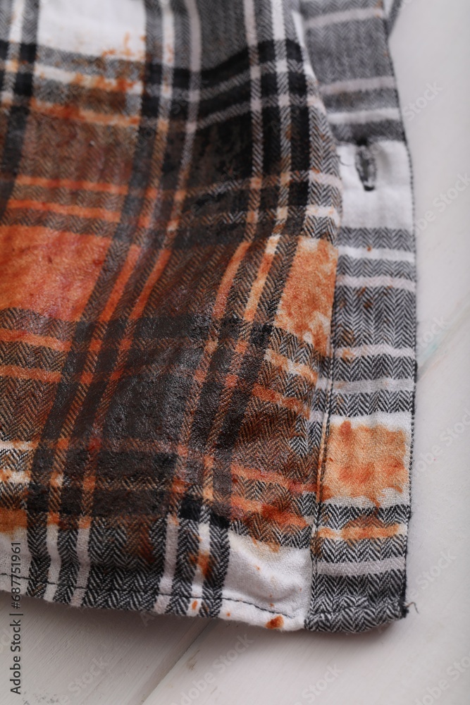 Shirt with stain of sauce on white wooden table, closeup Shirt with stain of sauce on white wooden table, closeup