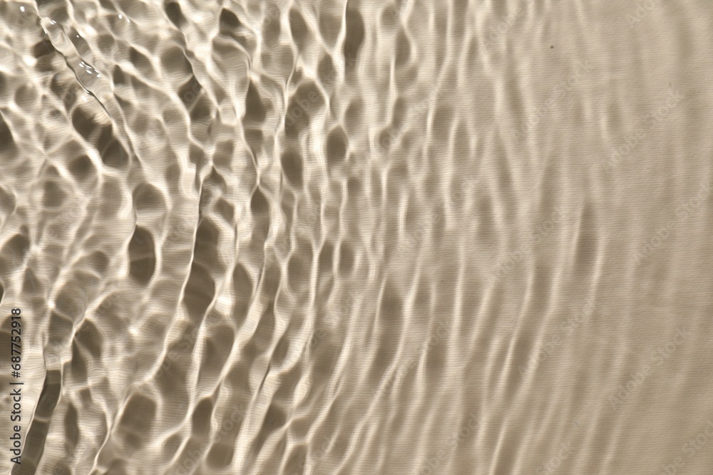 Rippled surface of clear water on beige background, top view Rippled surface of clear water on beige background, top view