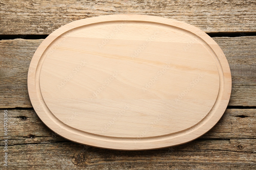 One new cutting board on old wooden table, top view One new cutting board on old wooden table, top view