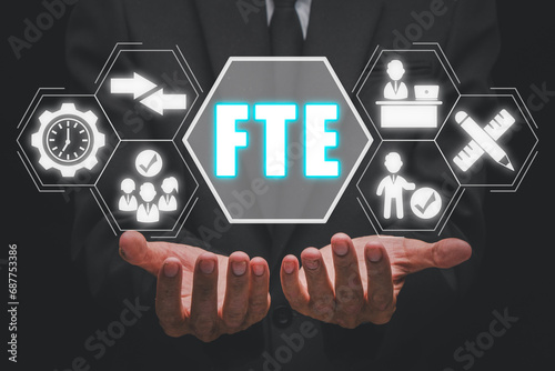 FTE, Full time equivalent concept, Businessman hand holding full time equivalent icon on virtual screen, equivalent, employee, workload, measure and comparability.