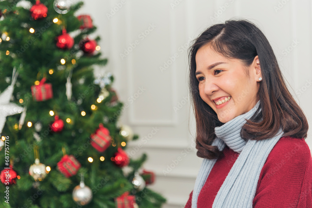 Asian Woman sitting christmas gift box under xmas tree got surprise present gift. Women smile talk sitting under decor bauble ball christmas tree xmas holiday winter festival celebrate in living room Asian Woman sitting christmas gift box under xmas tree got surprise present gift. Women smile talk sitting under decor bauble ball christmas tree xmas holiday winter festival celebrate in living room