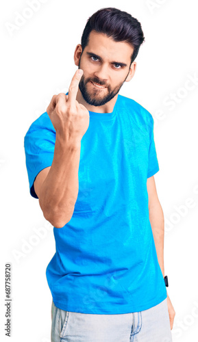 Young handsome man with beard wearing casual t-shirt showing middle finger, impolite and rude fuck off expression