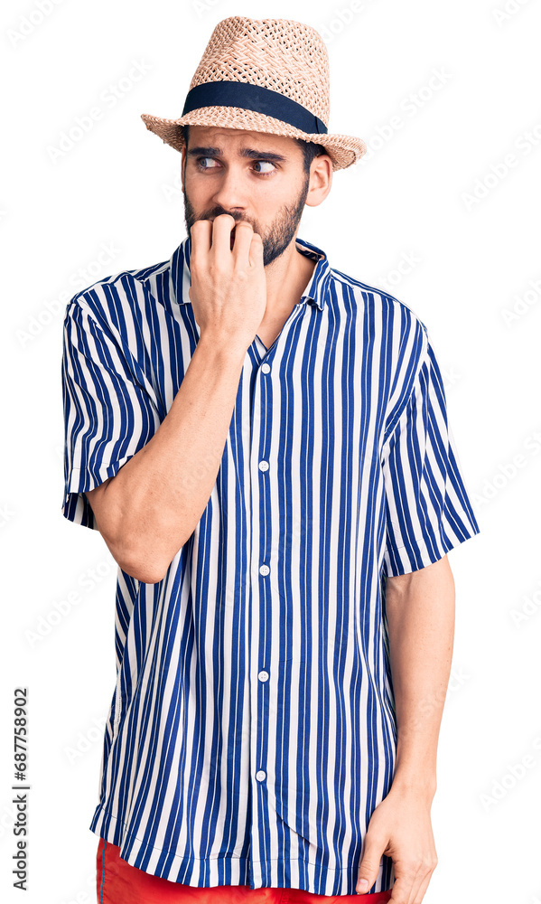 Young handsome man with beard wearing summer hat and striped shirt looking stressed and nervous with hands on mouth biting nails. anxiety problem. Young handsome man with beard wearing summer hat and striped shirt looking stressed and nervous with hands on mouth biting nails. anxiety problem.