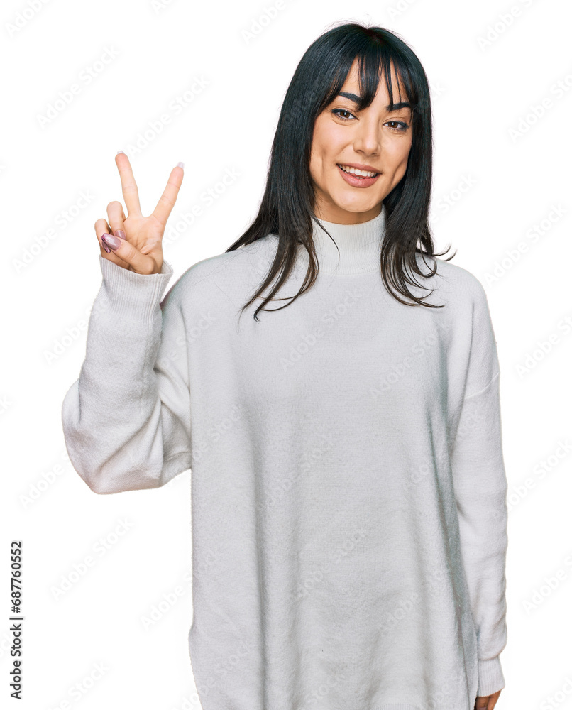 Young brunette woman with bangs wearing casual turtleneck sweater showing and pointing up with fingers number two while smiling confident and happy. Young brunette woman with bangs wearing casual turtleneck sweater showing and pointing up with fingers number two while smiling confident and happy.