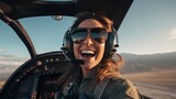A beautiful female pilot taking a selfie in the cockpit while piloting a plane with the sky in the background.