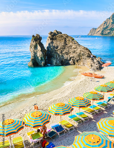 Pebble beach of Monterosso vacation Cinque Terre Monterosso Chairs and umbrellas fill the Spiaggia di Fegina beach Monterosso part of the Cinque Terre Italy. photo